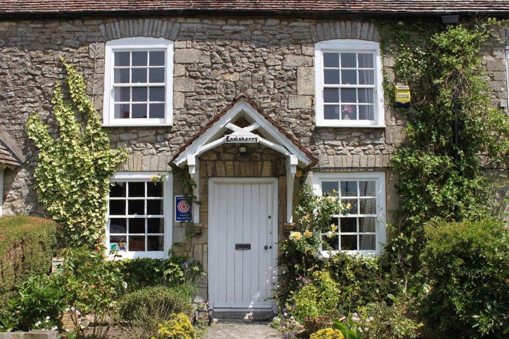谢普顿马利特Enniskerry - The Loves Cottage的石屋,设有白色门和两扇窗户