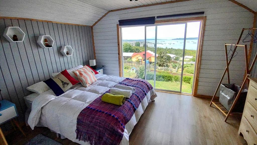 克利翁Inversiones MM Gallardo SPA - Altos de Yaldad Cabañas的一间卧室设有一张床和一个大窗户