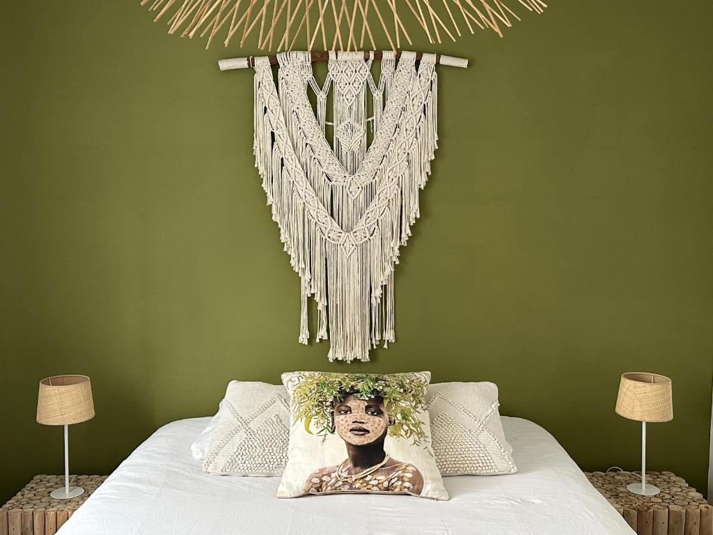 萨拉济Villa Couleur Nature的一间卧室设有绿色的墙壁和一张带床头板的床