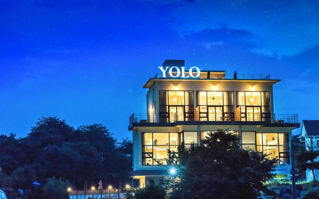 江陵市Yolo Spa Pension的一座建筑物,上面有夜间标志