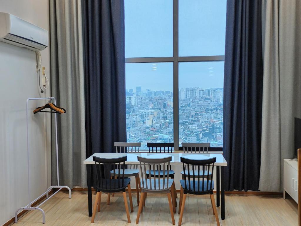 首尔JSM Studio Hongdae的餐桌、椅子和大窗户