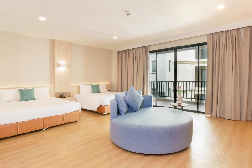 芭堤雅市中心Mike Garden Resort - SHA EXTAR PLUS的酒店客房,配有两张床和椅子