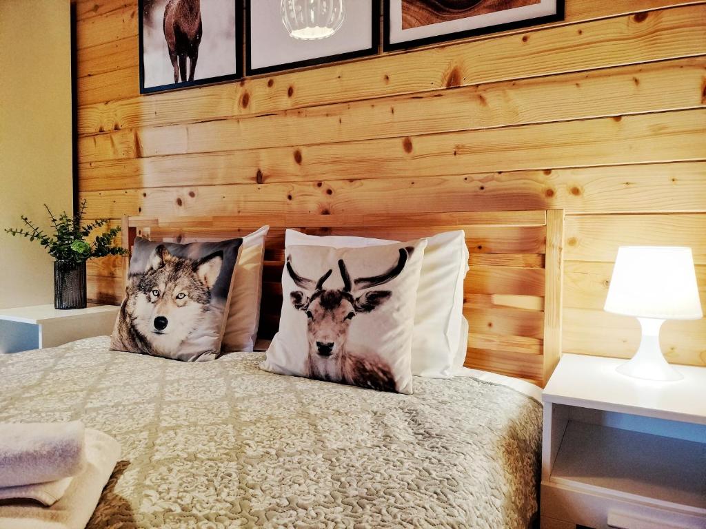 波兰尼卡-兹德鲁伊Pokoje i Domki Na Szlaku的一间卧室配有一张带两个鹿枕头的床