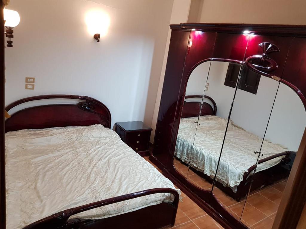 法尤姆Azzam Guest House 2 families only的一间卧室配有两张床和镜子