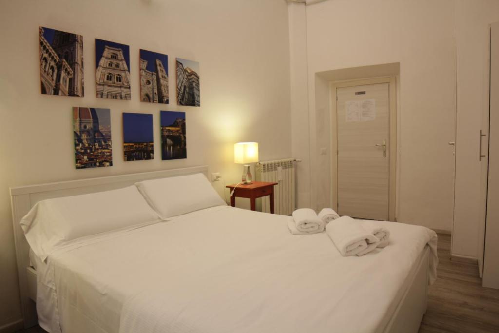 佛罗伦萨青铜马酒店的卧室配有白色床和毛巾