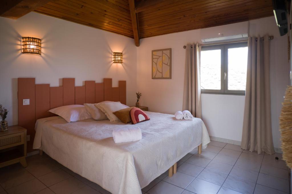 圣弗洛朗Hôtel - Restaurant U Santu Petru的一间卧室设有一张大床和一个窗户。