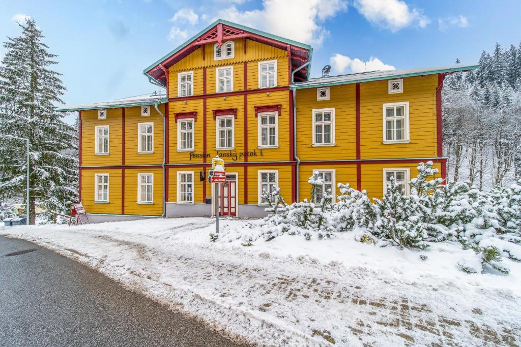 扬斯凯拉兹涅扬斯基波托克I.公寓的一座大橙色的建筑,前面有雪