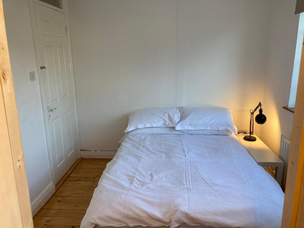 RiverchapelDetached two bedroom cottage的白色墙壁间的一张床位