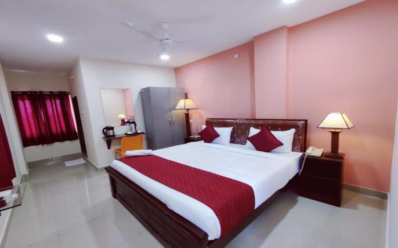 商沙巴Classic Hotel的一间卧室配有一张带红色和白色床单的大床