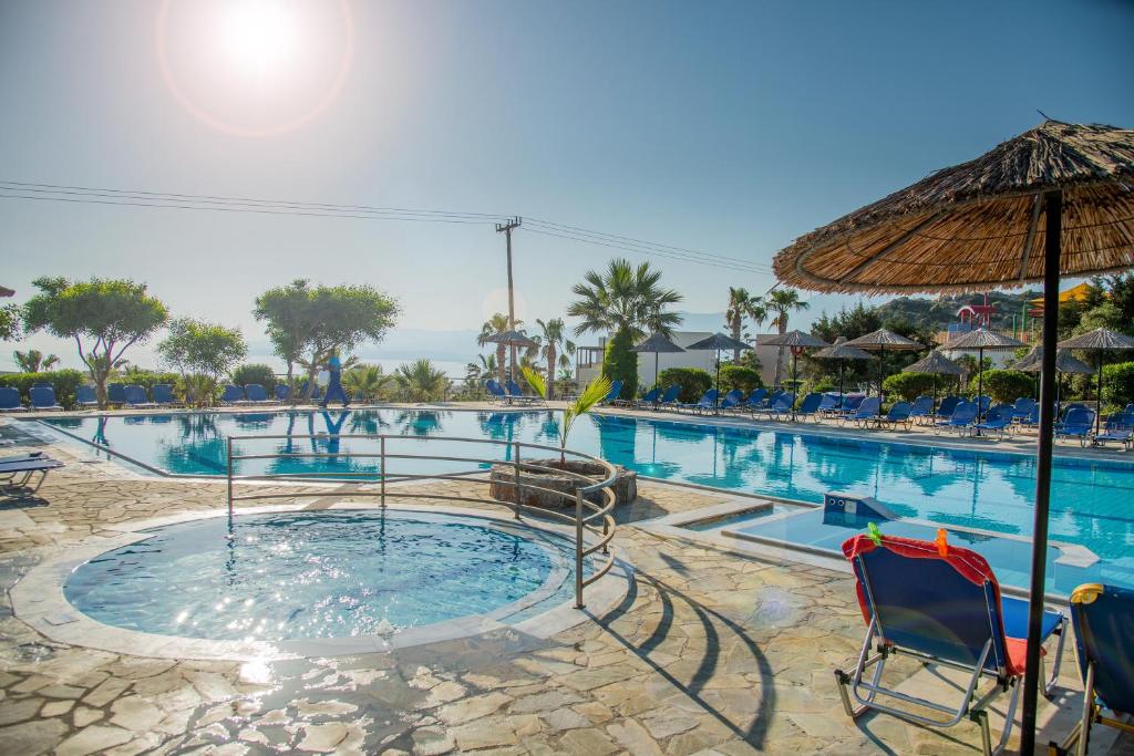 赫索尼索斯塞米勒米斯村酒店的一个带椅子和遮阳伞的游泳池
