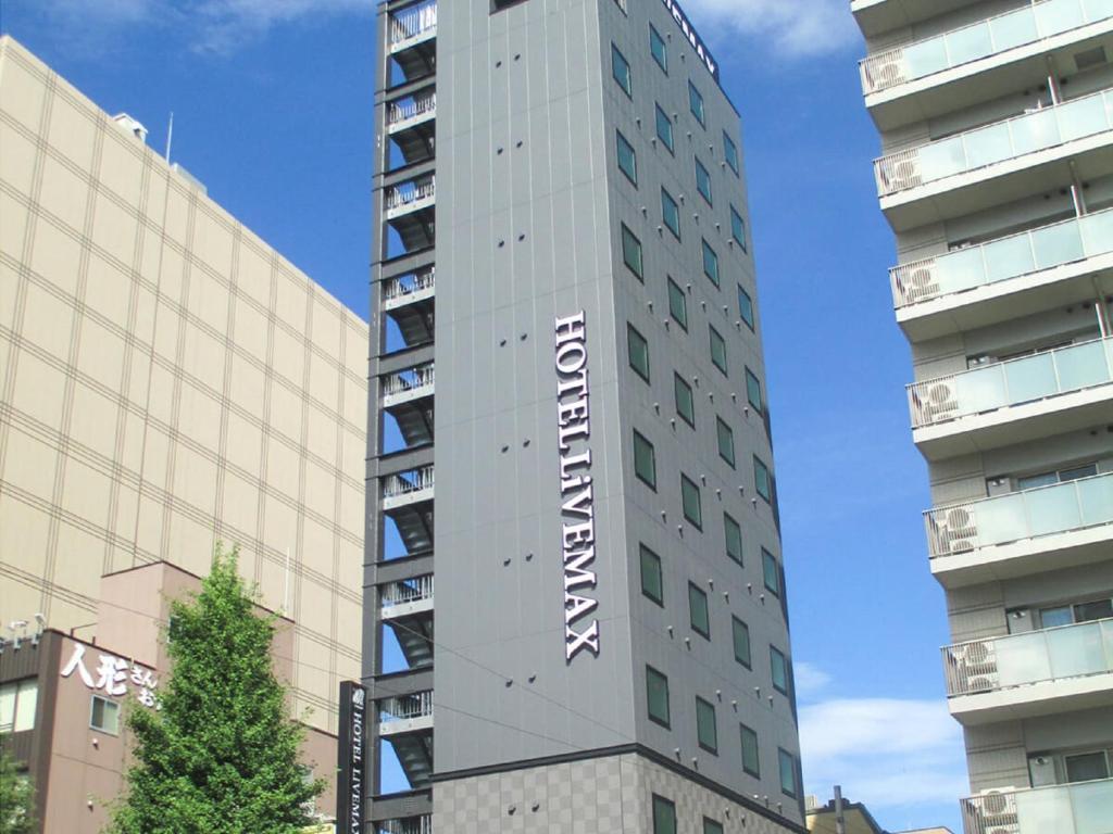 东京HOTEL LiVEMAX Asakusabashi-Eki Kitaguchi的一座高大的建筑,上面有标志