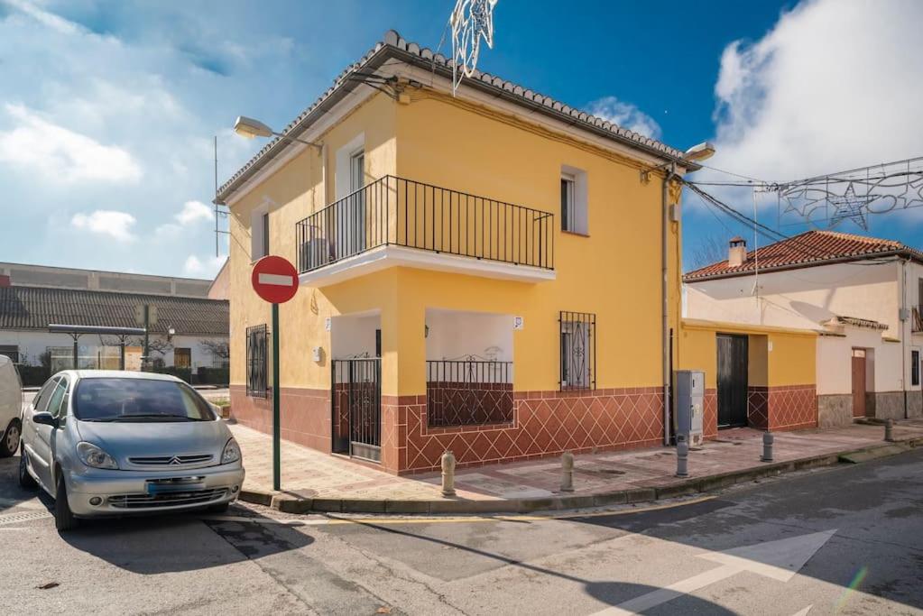 格拉纳达Casa Pablo -Granada-的停在黄色建筑前面的汽车