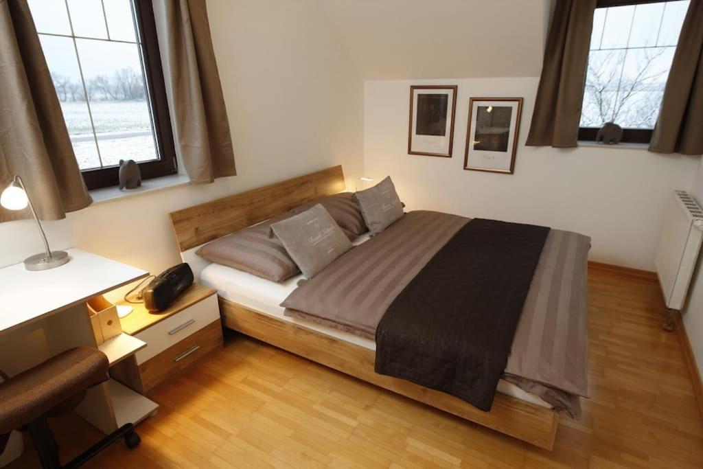 特赖斯基兴Traumhaft großes, sonniges Haus in Wien Nähe的一间卧室配有一张床、一张书桌和两个窗户。