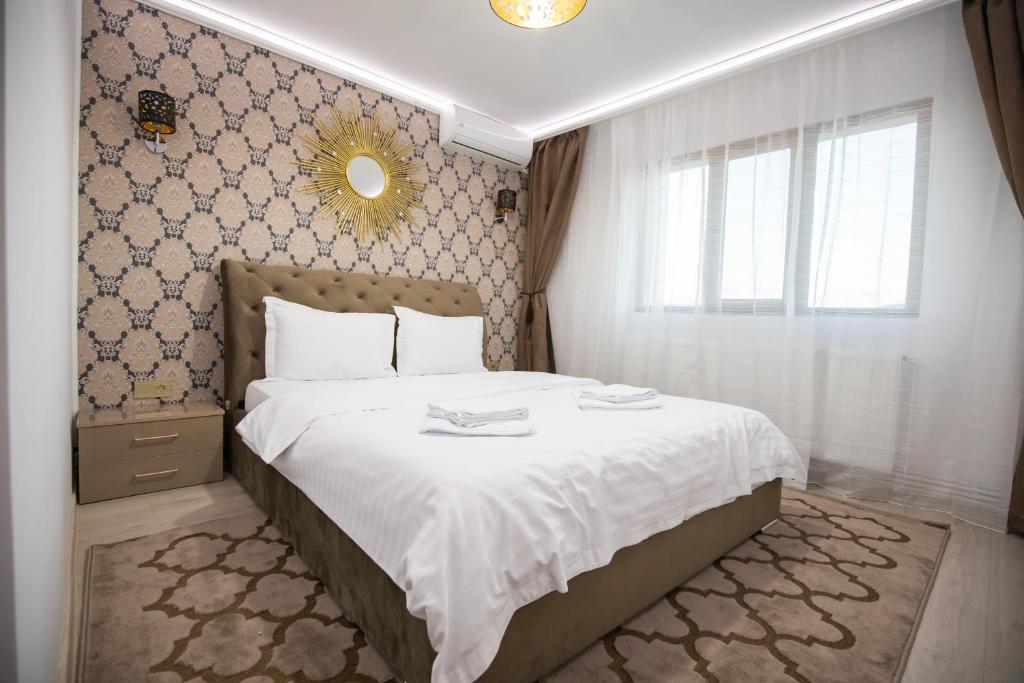 特尔古奥克纳Apartament Gold的一间卧室配有一张带白色床单和镜子的床