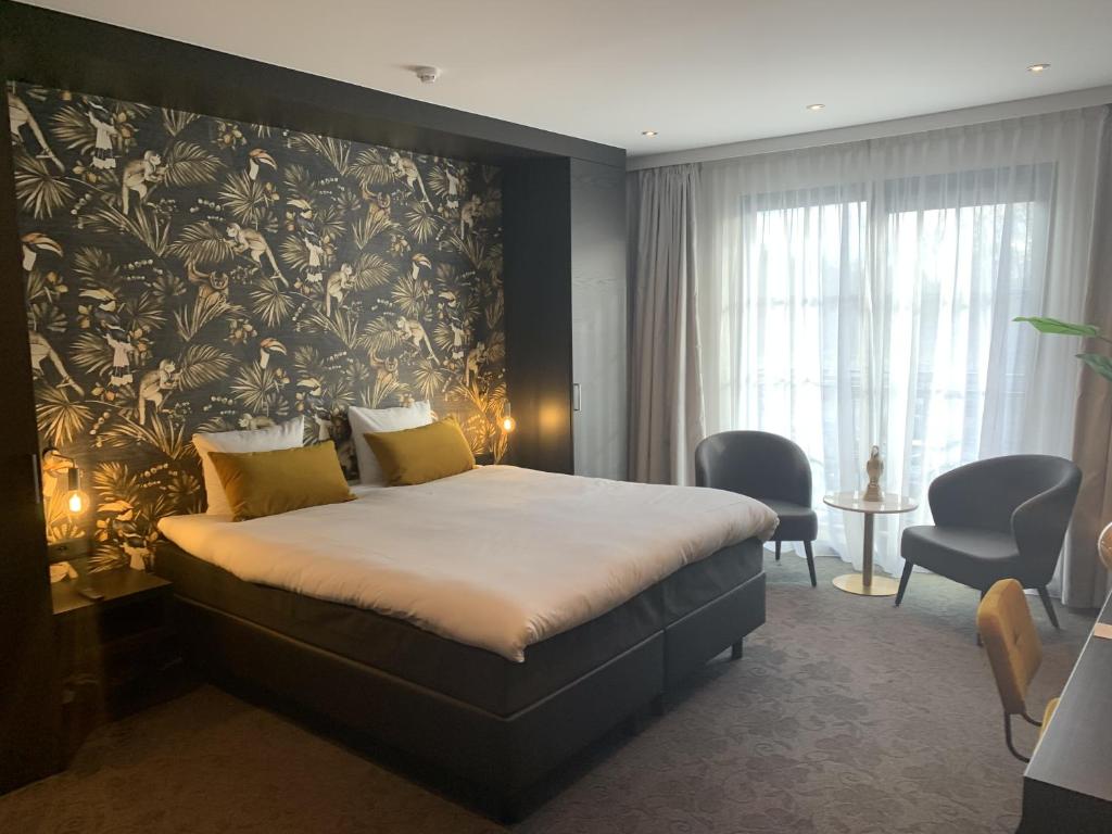 奥斯特坎普Van Der Valk Hotel Brugge Oostkamp的一间卧室配有一张带花卉壁纸的大床