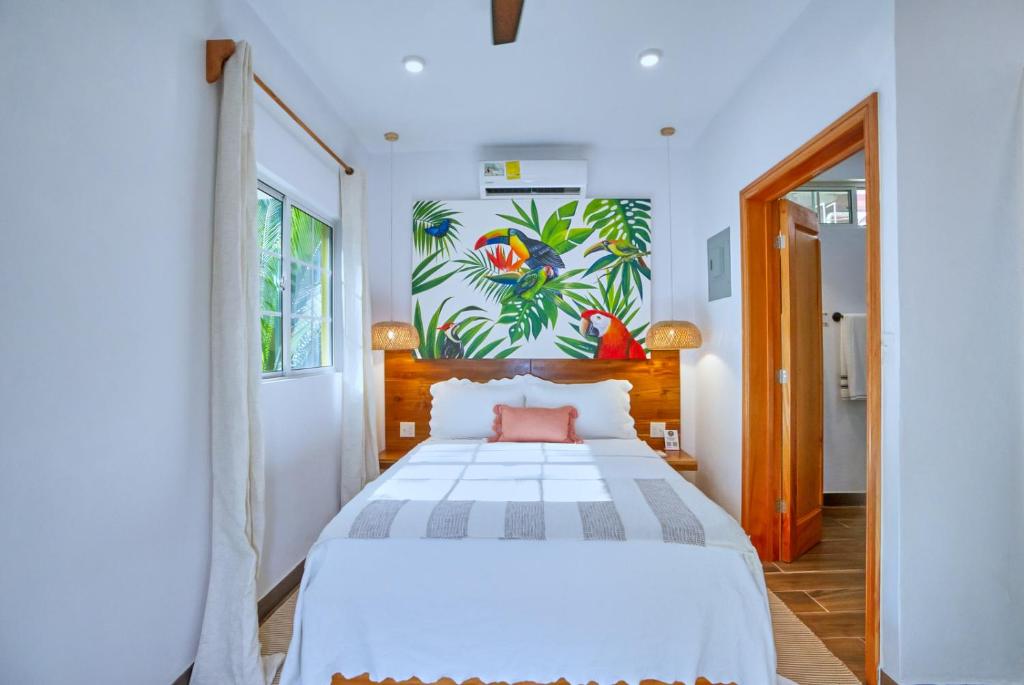 圣伊格纳西奥Villa Massis Luxury Villas的卧室配有白色的床和墙上的绘画作品