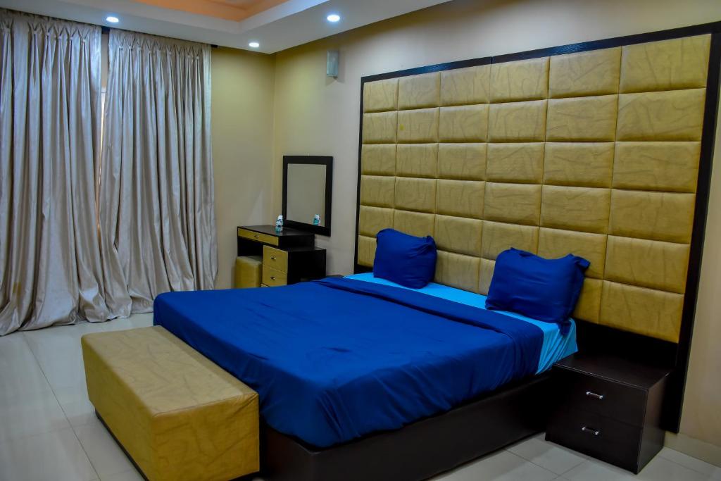 拉各斯Beautiful Town House的一间卧室配有一张带蓝色床单和蓝色枕头的床。