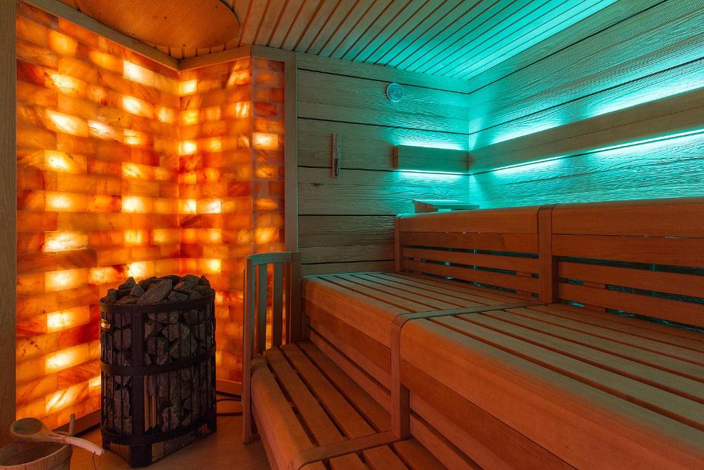 奥斯赛拜-屈隆斯博恩HOTEL am STRAND的一个带木凳和垃圾桶的桑拿浴室