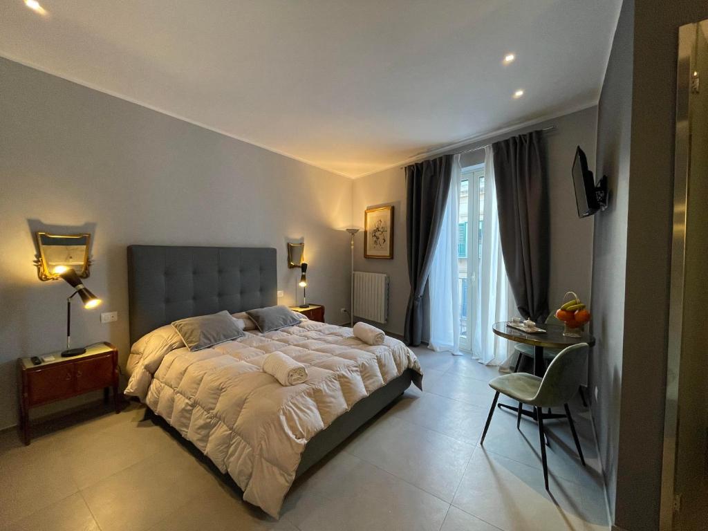 巴勒莫Dimora San Gregorio Luxury Rooms的卧室配有1张床、1张桌子和1把椅子