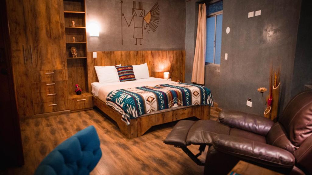 基多Chakana Hotel Boutique Centro的一间卧室配有一张床、一张沙发和一把椅子