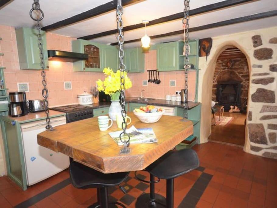 SancreedGranite Country Cottage west of Penzance的厨房配有木桌和一些椅子