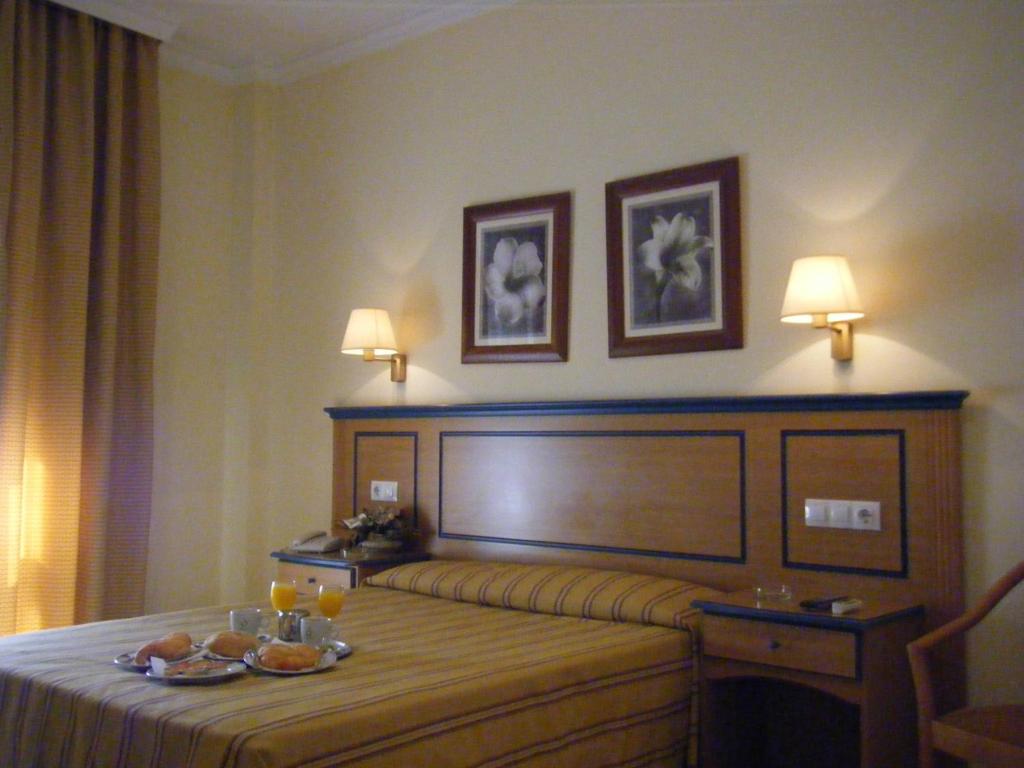 阿尔赫西拉斯米拉多尔酒店的酒店客房,配有一张带餐桌的床,上面有食物