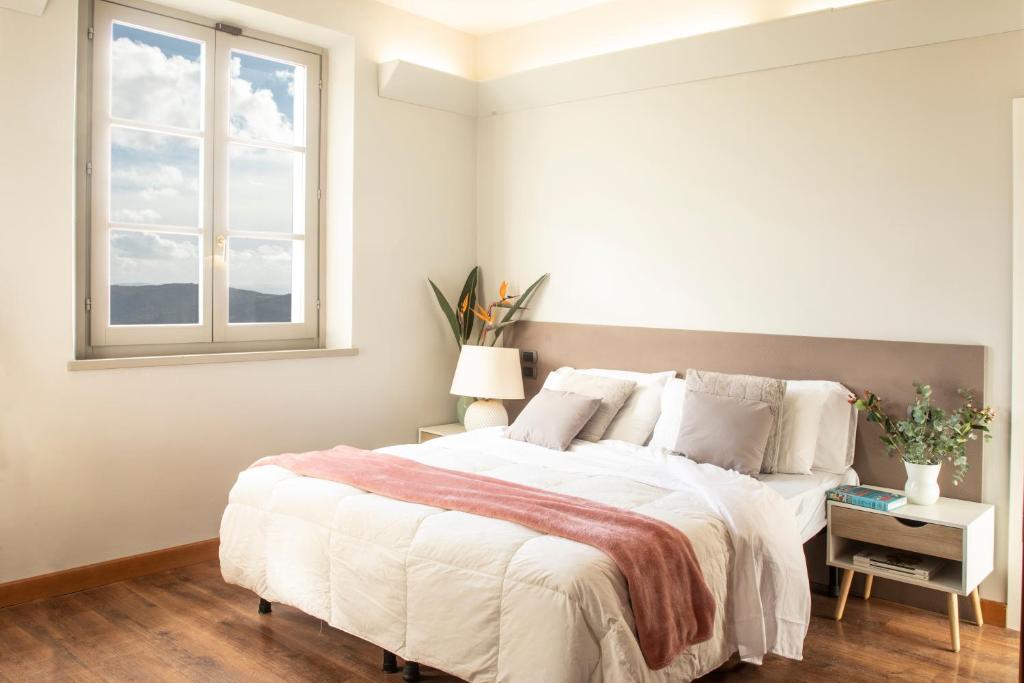 科尔托纳Locanda agli Amici的一间卧室设有一张大床和一个窗户。