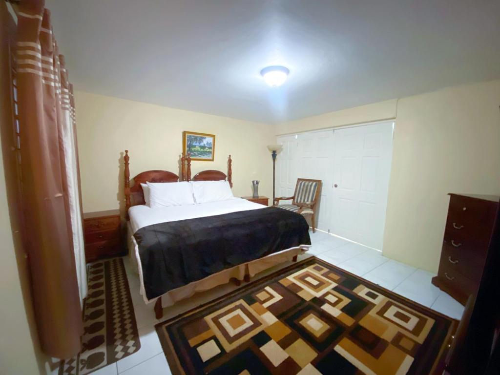 金斯敦Russell Heights Vacation Home的一间卧室配有一张大床和地毯。