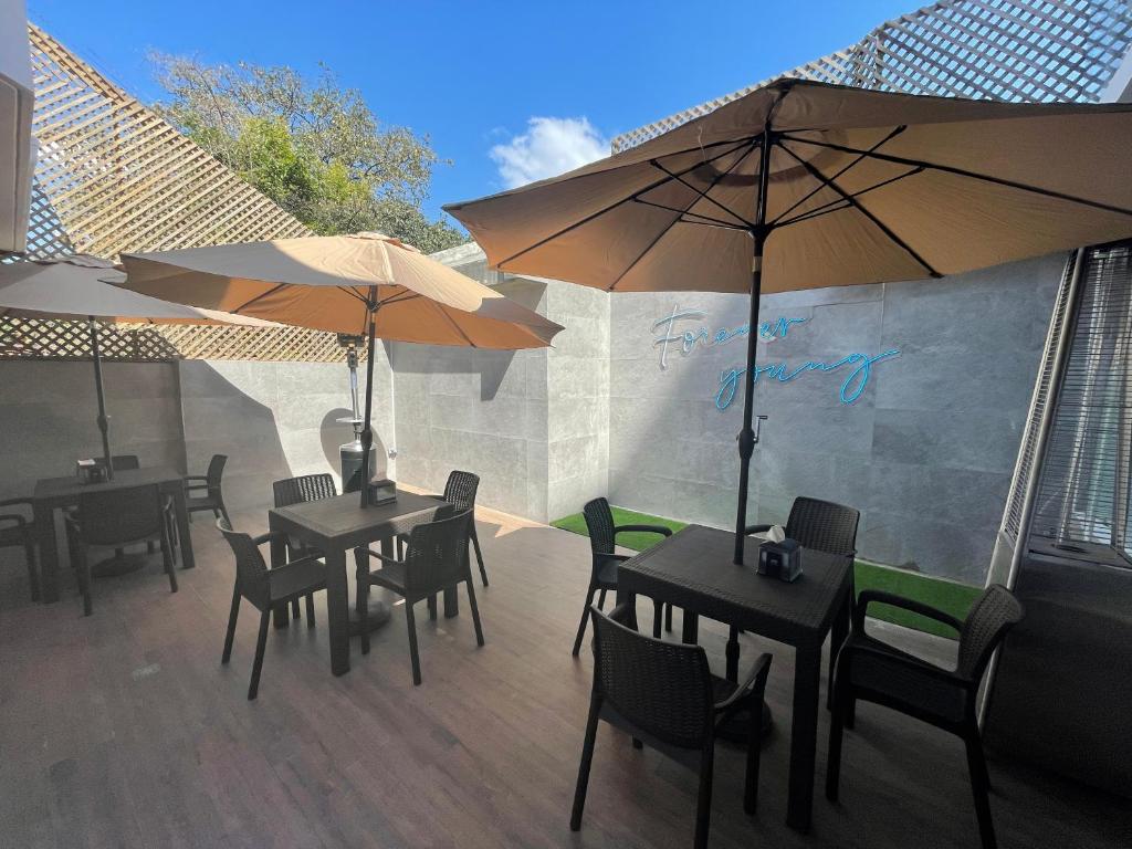 危地马拉Hotel Villas Santander的庭院里配有两张桌子和椅子以及遮阳伞