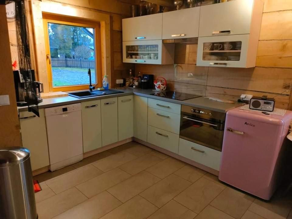 下乌斯奇基BIJAKÓWKA的厨房配有白色橱柜和粉色冰箱