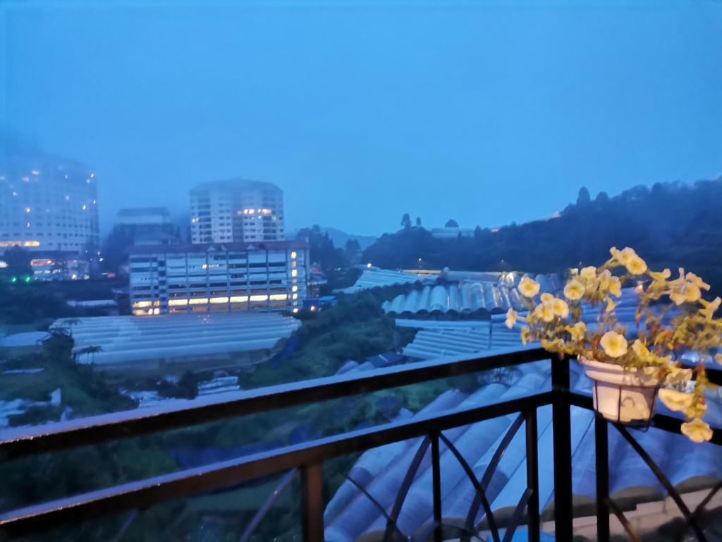 伯恩仓Dzulstudio(Muslim) Nova Highland的从鲜花盛开的建筑的阳台上可欣赏到风景