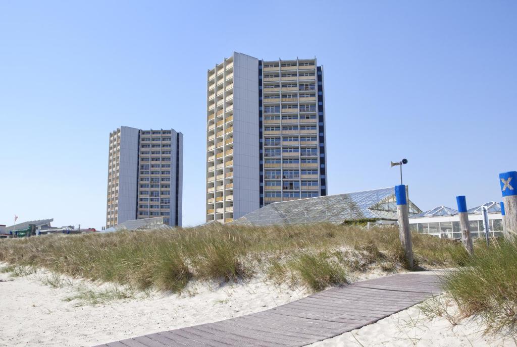 伯格奥夫费马恩费马恩岛IFA假日酒店的海滩上两栋高楼,有木板路