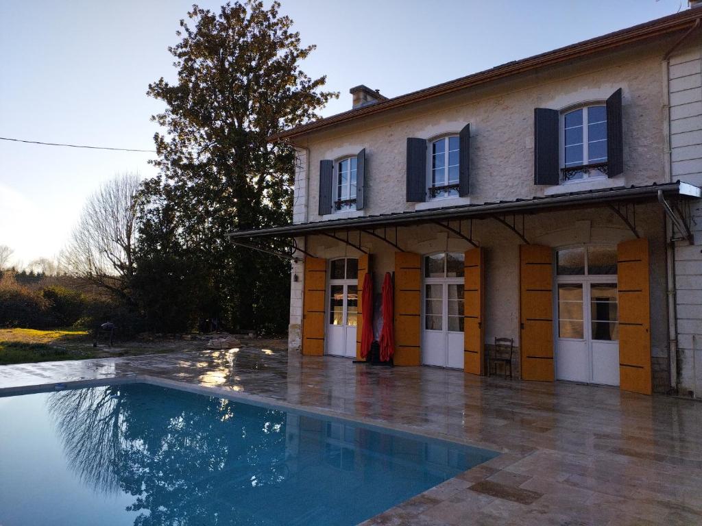 圣耐克森A la Gare的一座房子前面设有游泳池