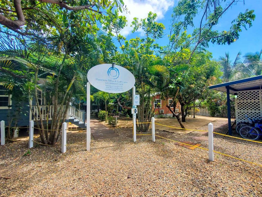 珀拉什奇亚Placencia Villas的树木丛生的建筑前的标志