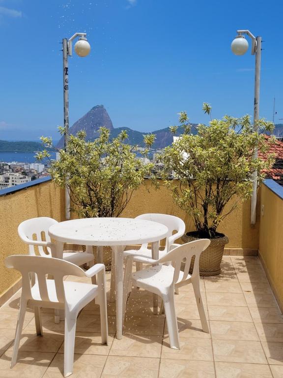 里约热内卢Santo Mirante Hostel的阳台上配有白色的桌椅