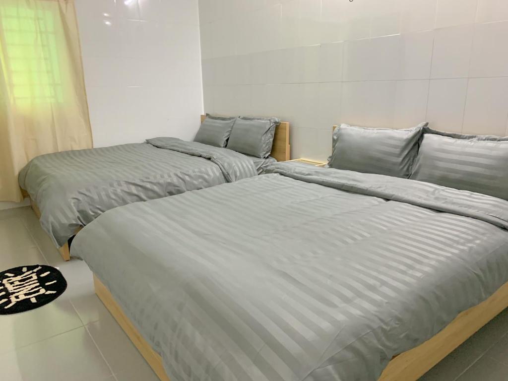 áº¤p VÄ©nh ÃÃ´ngDeMi Homestay - Châu Đốc的两张睡床彼此相邻,位于一个房间里