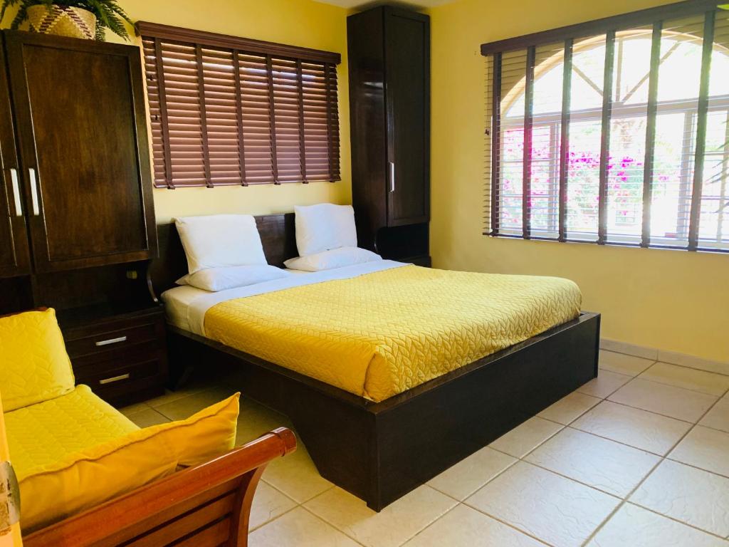 棕榈滩蛋白石之家酒店的一间卧室设有一张黄色墙壁和窗户的床