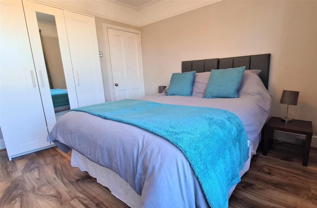 雷利Castle Cottage的一间卧室配有一张带蓝色枕头的大床