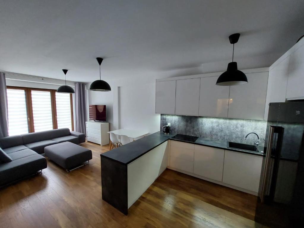 威利兹卡Apartament Reformacka的一间带白色橱柜的厨房和一间客厅