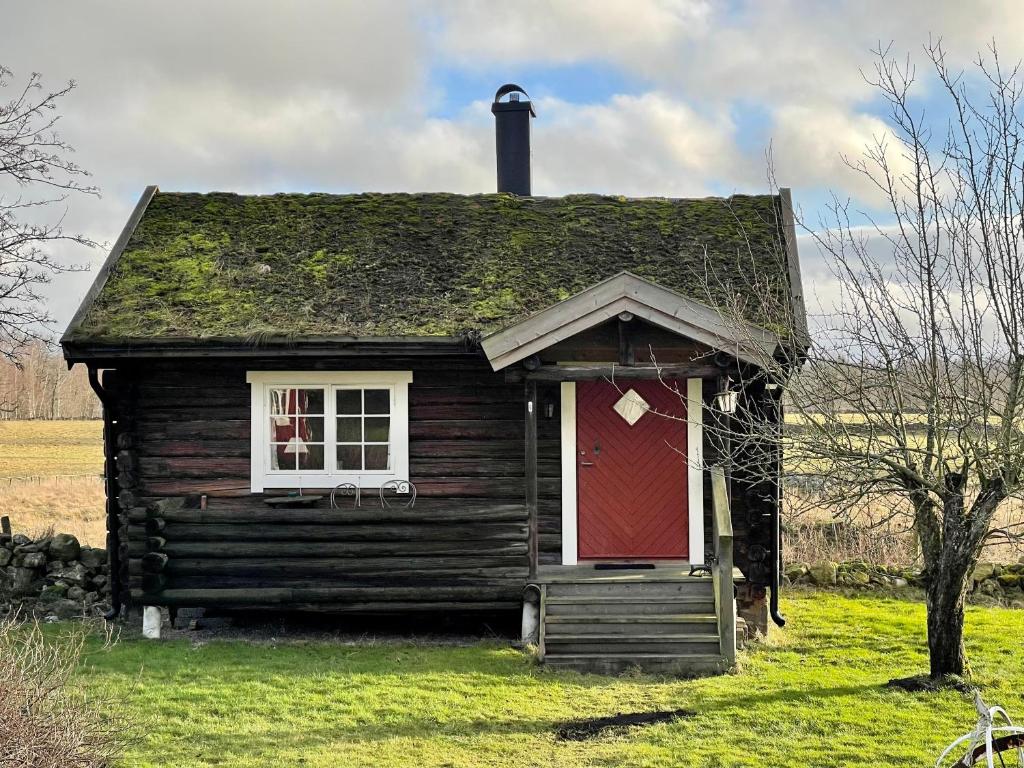 法尔雪平Backgårdens Timmerstuga的一座带红色门和窗户的旧房子