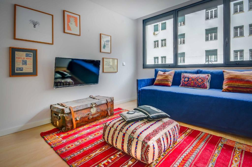 里斯本里斯本服务公寓 - 里博瑞戴德的客厅设有蓝色的沙发和大窗户