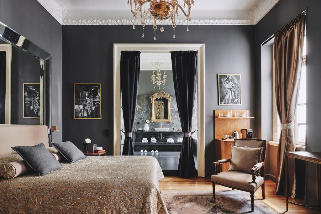 雅典Bohemian Suites Athens的一间卧室配有一张床和一把椅子