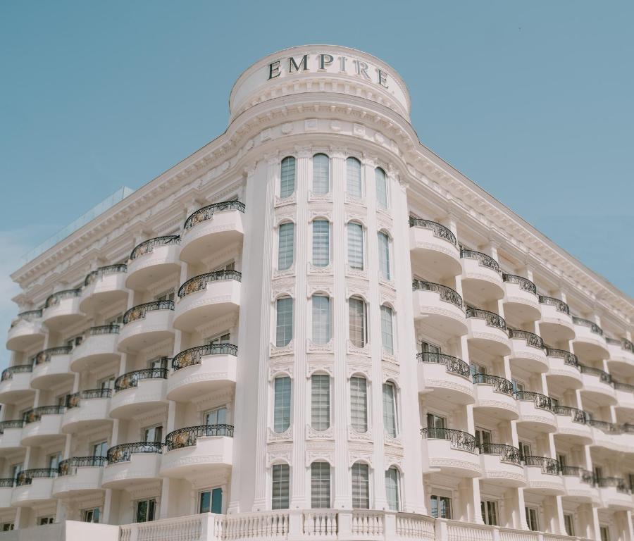 都拉斯Hotel Empire Albania的一座白色的大建筑,上面有标志
