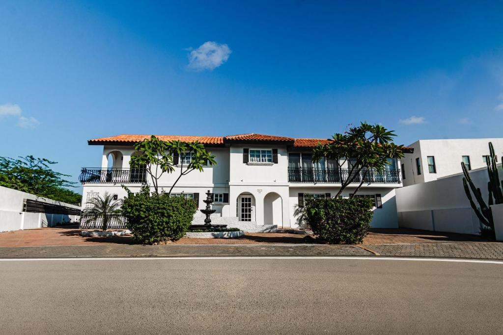 棕榈滩Villa Fontana 1 & 2的街道前有树木的白色房子