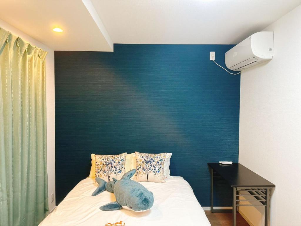 大阪Linn 阿倍野的一张带蓝色床头板的床,上面有种动物