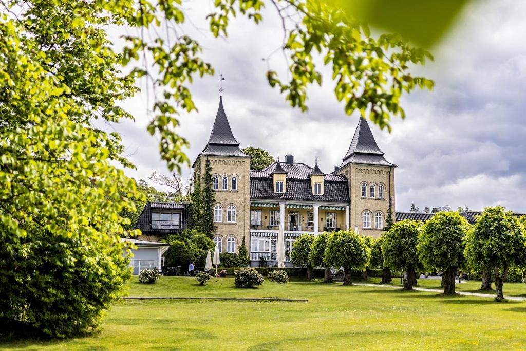 莫斯Hotel Refsnes Gods - by Classic Norway Hotels的一座大型建筑,在草地上有两个塔楼