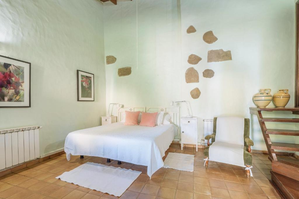 贝加德圣马特奥卡莱斯乡村酒店的卧室配有白色的床和白色椅子