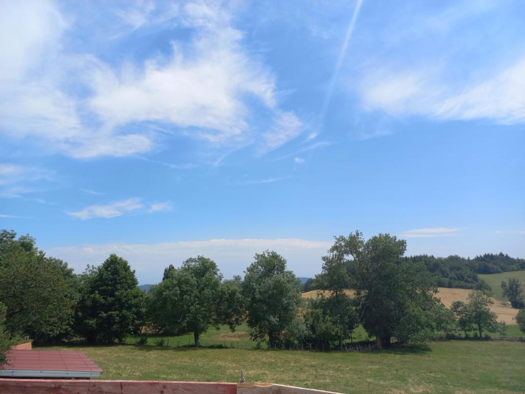 ColombierLa Grange de Léobin的享有绿树成荫的田野和蓝天的景致