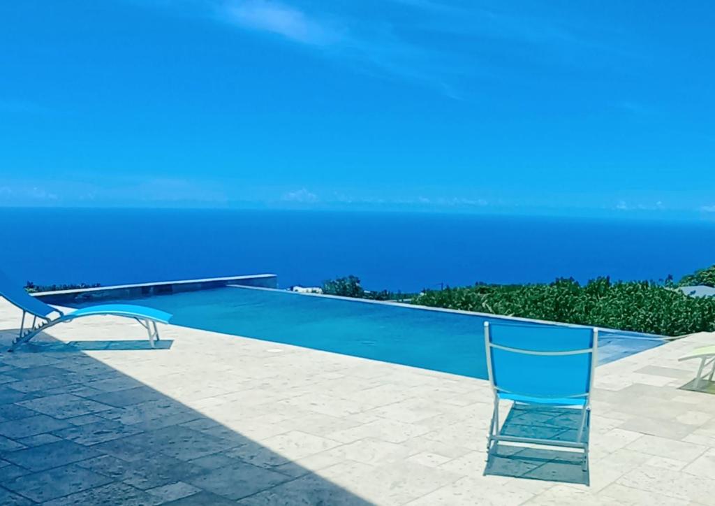 珀蒂蒂勒Villa Mahot的蓝色游泳池旁设有椅子
