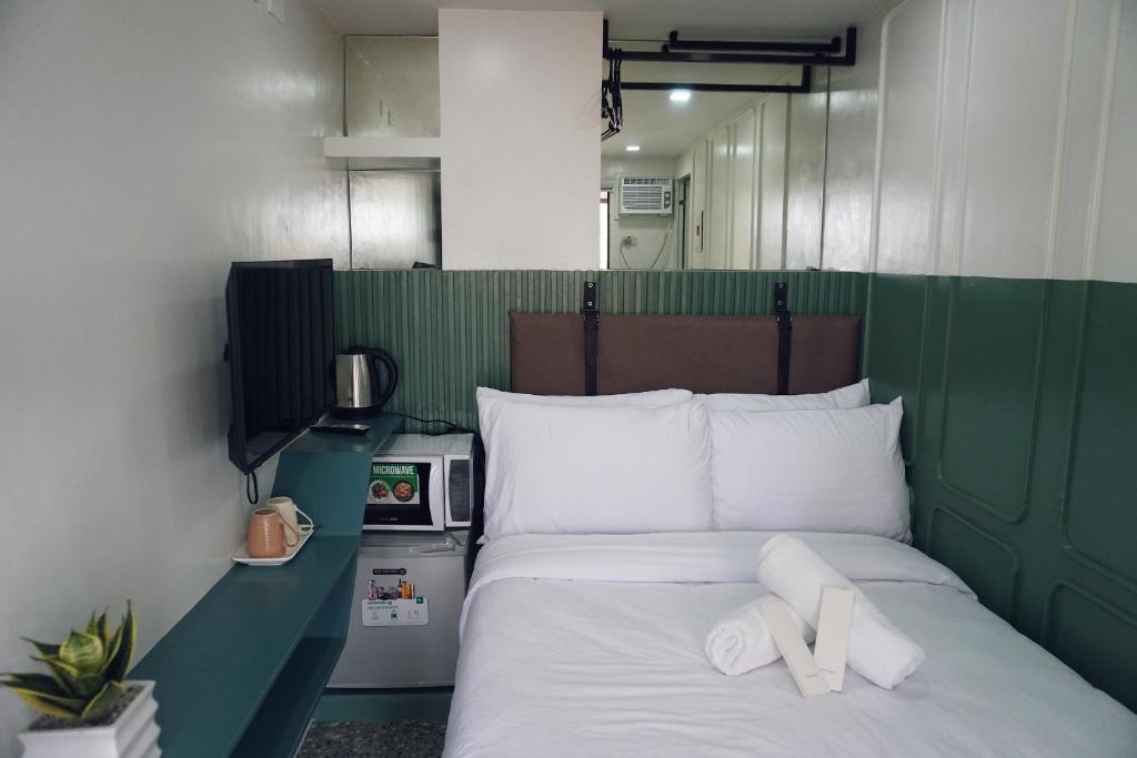 宿务Cebu Backpackers Hostel的一张绿色的白色床,上面有两条白色的毛巾